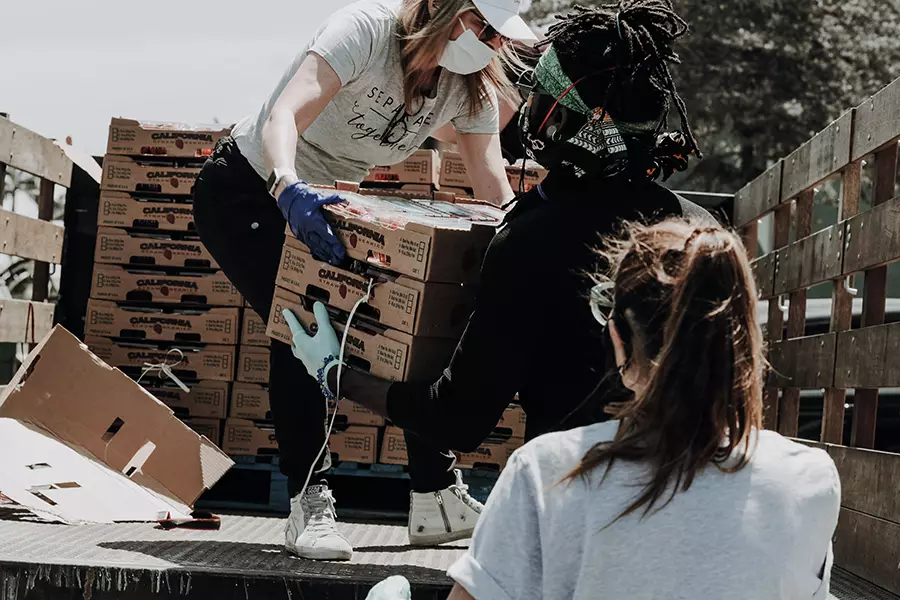 A group of people unload produce from a truck