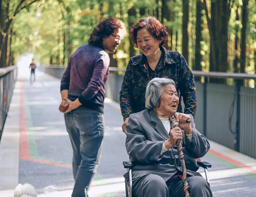 Elderly woman in a wheelchair being pushed by another woman